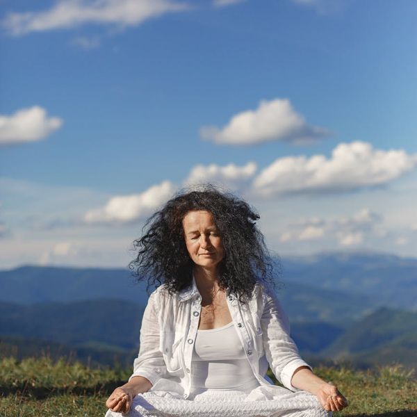 Person meditating peacefully in a calm and beautiful environment.